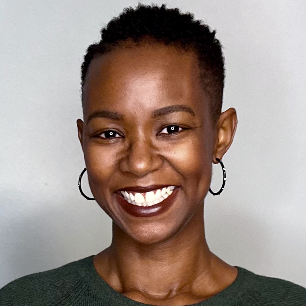 A woman with short black curly hair and hoop earrings